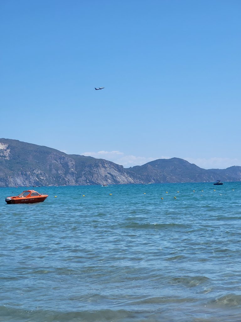 looking out to sea at Laganas with a plane taking off above it.