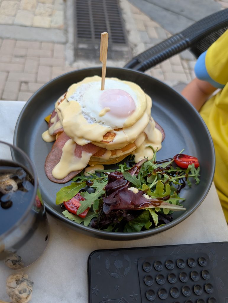 A stack of pancakes topped with a fried egg